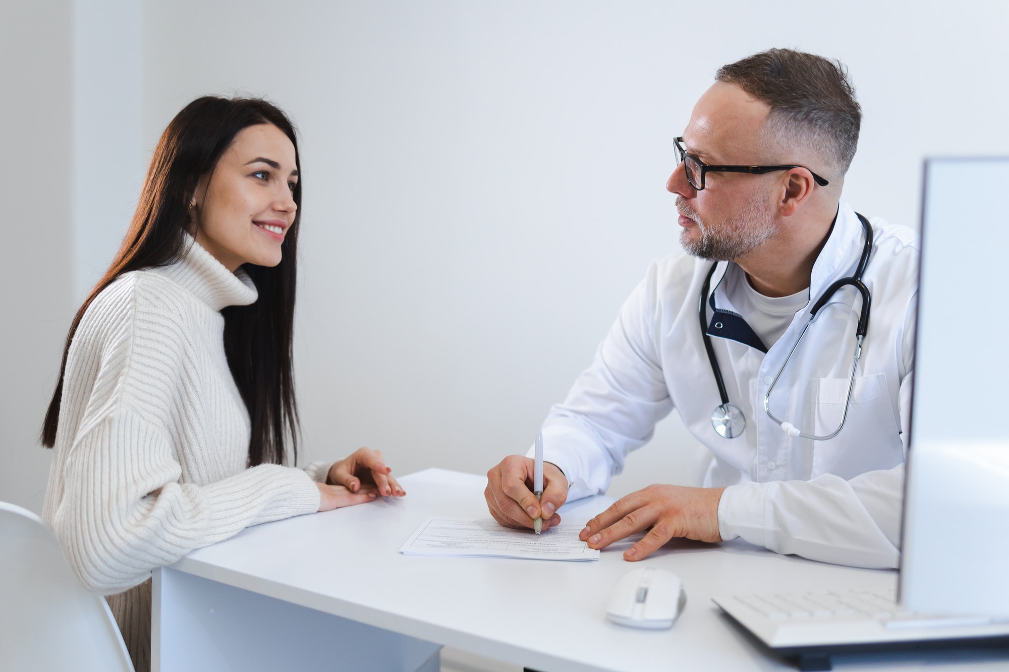 Male doctor writes a treatment plan for the female patient